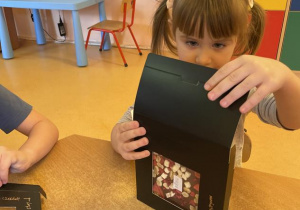 dzieci pakują swoje czekolady do dekoracyjnych pudełek